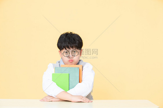 为学习发愁的小男孩抱着书的男孩图片
