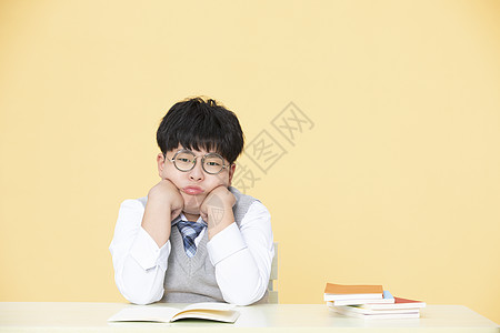 复习孩子为学习发愁的小男孩不想做作业背景