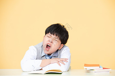 儿童学习用品小男孩学习中打哈欠精神不集中背景