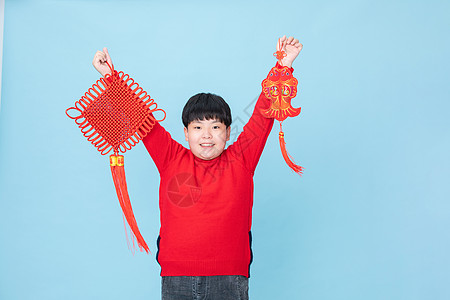 2021小男孩过春节拿着中国结和鱼背景