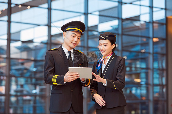 飞行员和空姐手持平板交谈图片