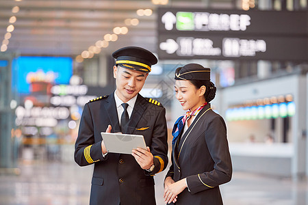 飞行员和空姐手持平板交谈图片