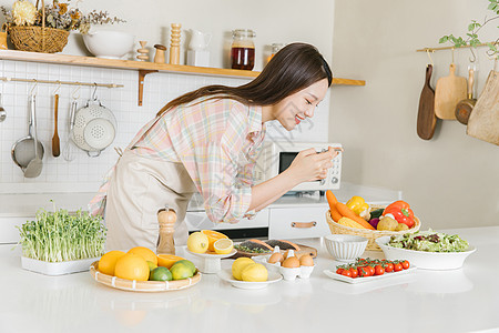 居家美女厨房菜品拍照图片