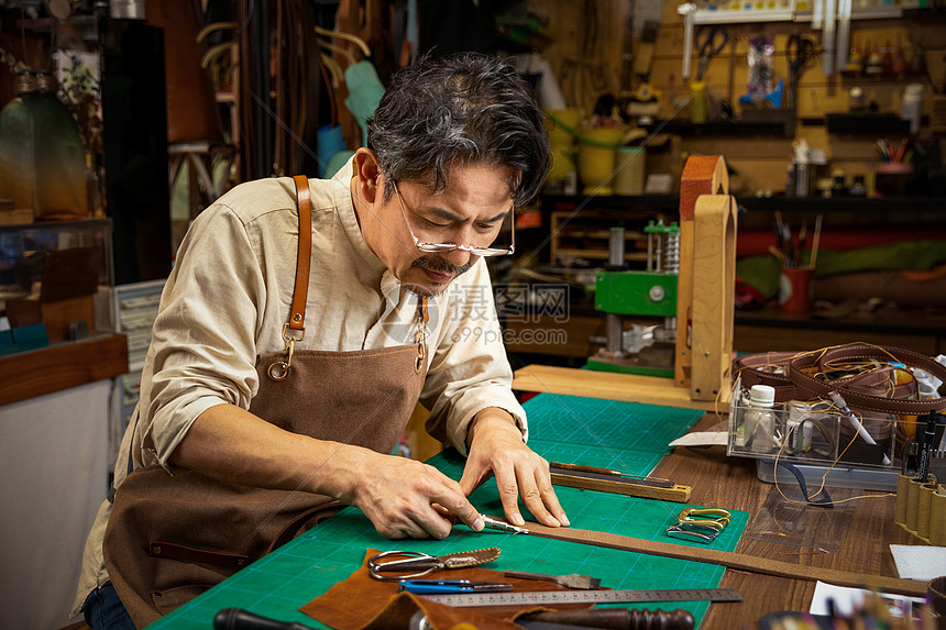 男性工匠手工制作皮带图片