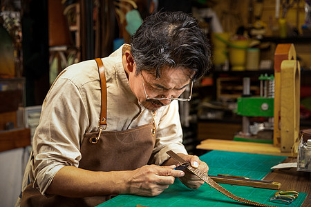 男性工匠手工制作皮带图片