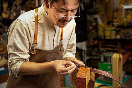 男性工匠手工制作皮带图片