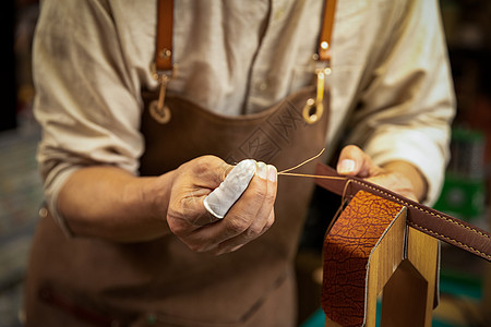 男性工匠手工制作皮带特写图片