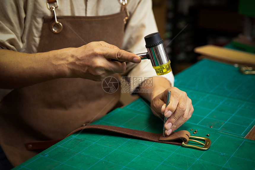 男性工匠手工制作皮带特写图片