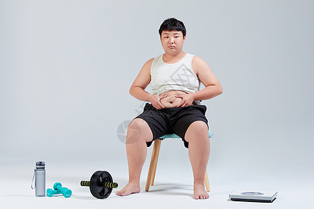 骑车减肥男孩摸肚子的小胖子运动减肥背景