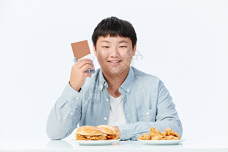 开心的吃巧克力的肥胖男孩图片