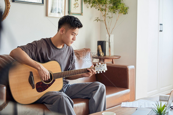 年轻男士在家弹吉他图片