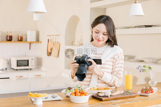 居家女孩使用相机拍摄美食图片