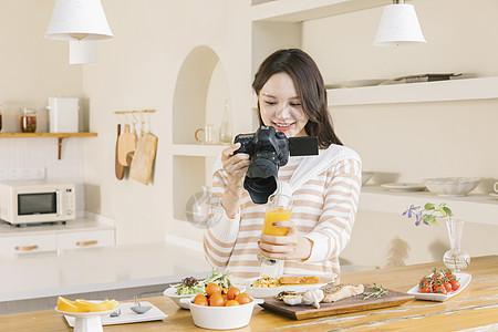 居家女孩使用相机拍摄美食图片