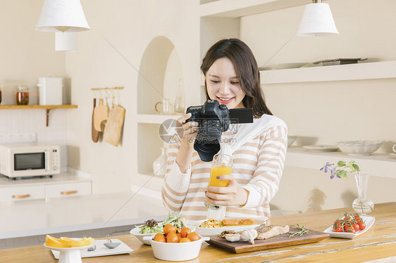 居家女孩使用相机拍摄美食图片