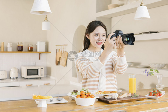 居家女孩使用相机拍摄美食图片