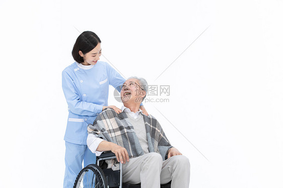 护士给轮椅上的老人披上披风图片