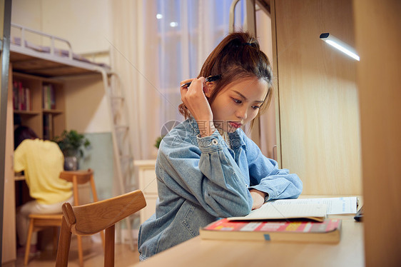 女大学生考研前在宿舍认真复习图片