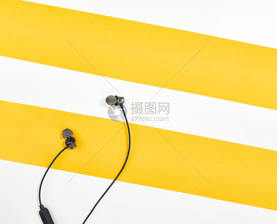 耳机放置在白黄拼接色桌面图片