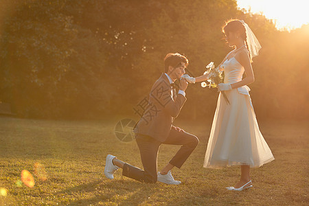 婚纱写真夕阳下年轻男士向女友求婚背景