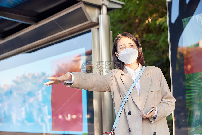 戴口罩公交站台打车的青年女生图片