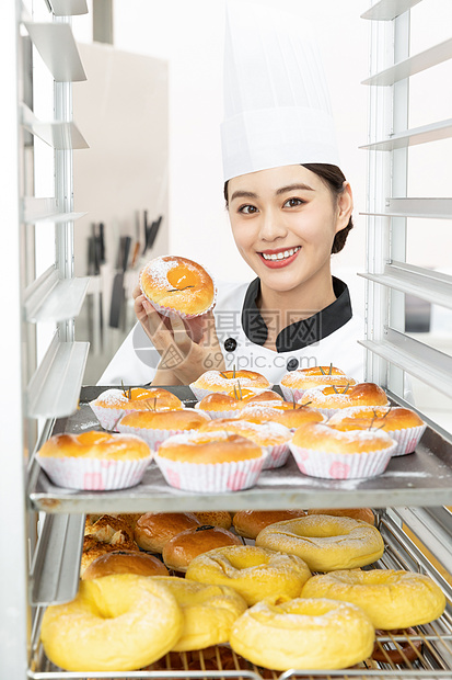 女性烘焙师烘烤面包图片