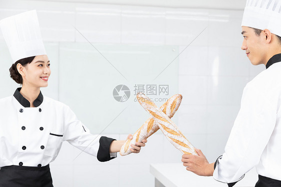 烘焙学校学生拿面包法棍打闹图片