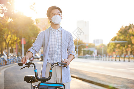 佩戴口罩的男性为共享单车消毒图片