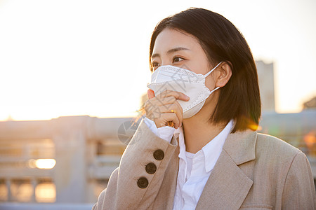 户外佩戴口罩的都市女性图片