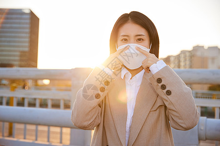 户外佩戴口罩的都市女性图片