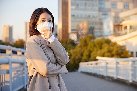 户外佩戴口罩咳嗽的青年女性图片