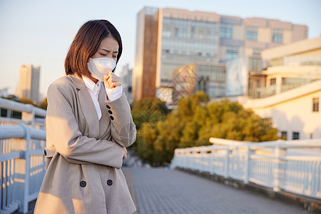 防护口罩佩戴户外佩戴口罩咳嗽的青年女性背景