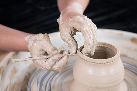 陶艺匠人手工制作切割陶艺品特写图片