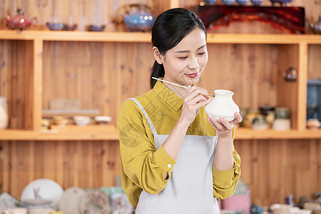 美女手工绘制陶艺罐图片