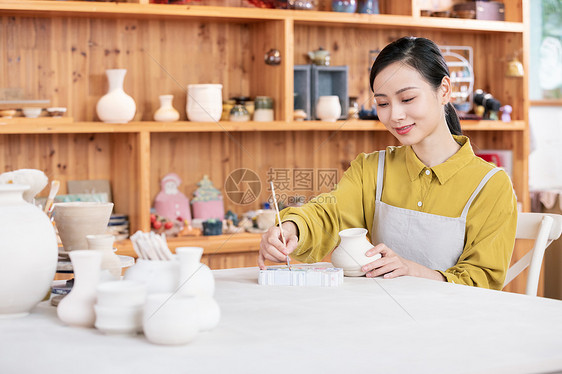 美女手工绘制陶艺罐图片