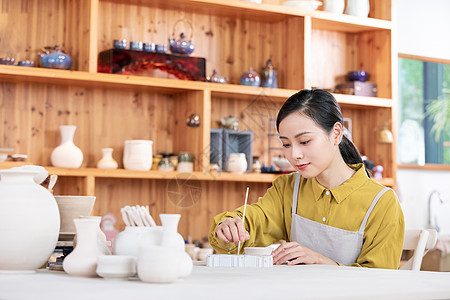 美女手工绘制陶艺罐图片