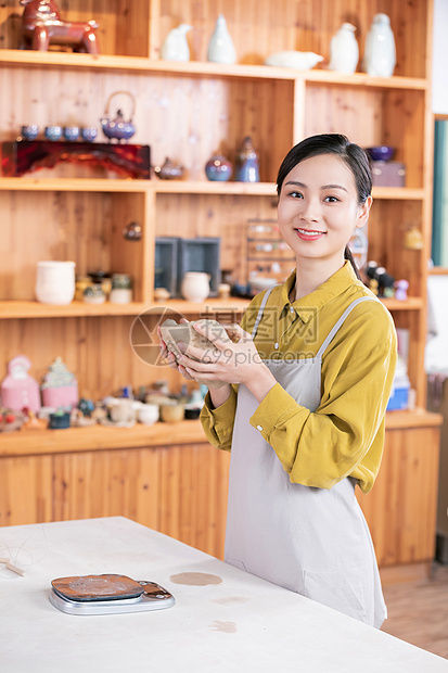 美女给陶土称重图片