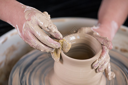 男性匠人手工制作陶艺制品特写图片