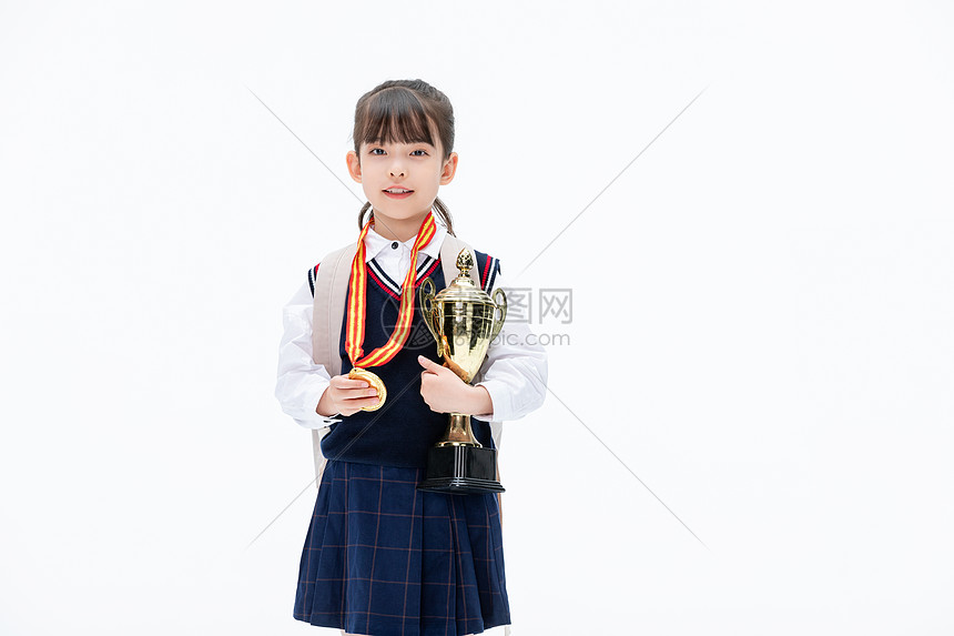 背书包的小女孩手里拿抱奖杯图片