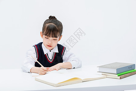 小女孩在课桌前学习做作业图片