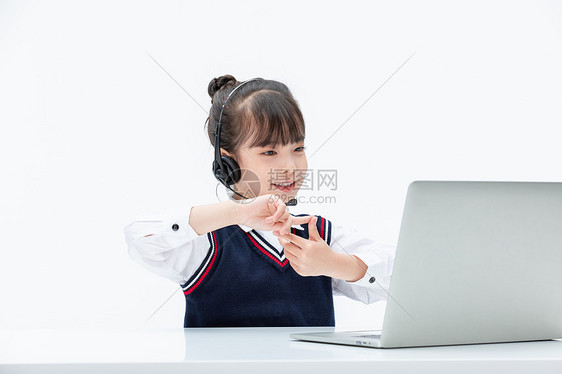 小女孩使用电脑线上学习听课做动作图片