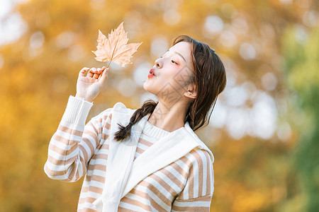手拿树叶的秋季可爱女孩图片