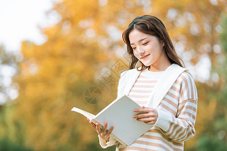 美女写真手捧书本的清新文艺秋季美女背景