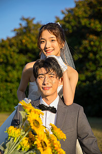 结婚礼服浪漫户外时尚情侣手拿向日葵背景