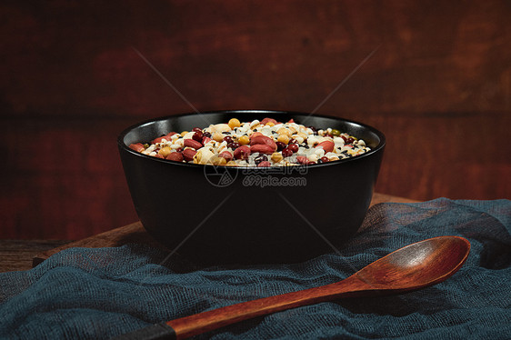 黑色碗里的腊八粥原材料和勺子图片