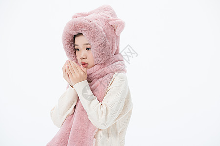 手上滑落戴着围巾的女孩在手上哈气背景