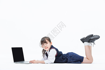 小女孩趴在地上使用笔记本电脑学习图片