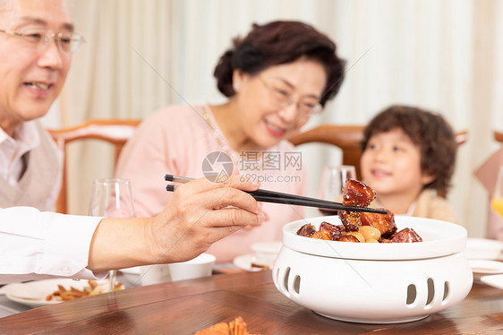新春家庭年夜饭夹菜红烧肉特写图片
