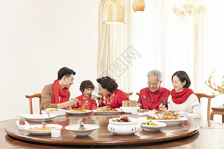 新春年夜饭奶奶夹菜喂小男孩高清图片