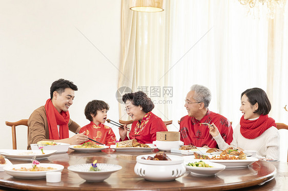 新春年夜饭奶奶夹菜喂小男孩图片