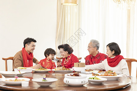 新春年夜饭奶奶夹菜喂小男孩图片